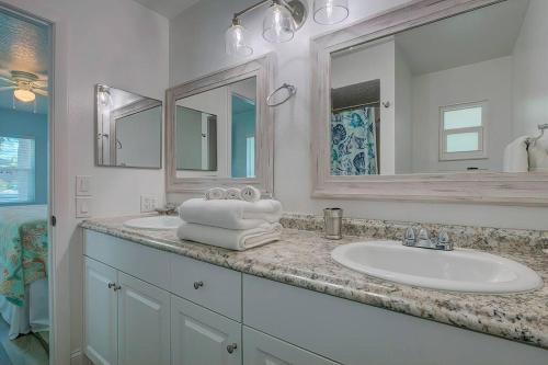 ein weißes Badezimmer mit einem Waschbecken und einem Spiegel in der Unterkunft Direct gulf access with boat dock minutes from Weechi Wachee in Hernando Beach