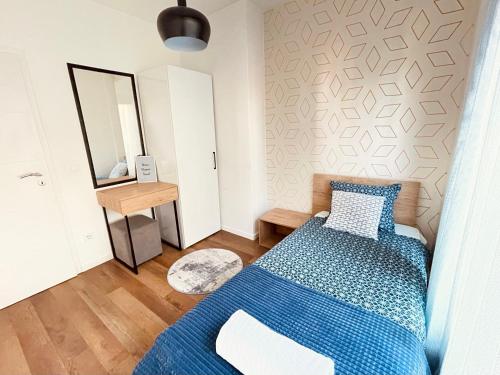 a bedroom with a blue bed and a mirror at Tower apartment in Pristina