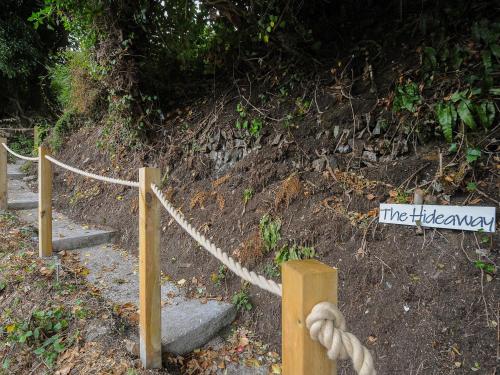 a rope tied up on a dirt hill with a sign at The Hideaway in Chacewater