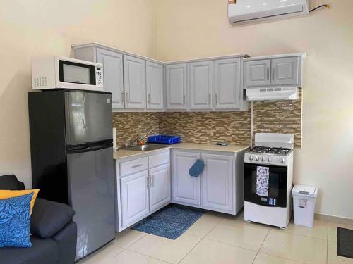 a kitchen with white cabinets and a microwave and a refrigerator at Cozy Studio Apartment in Quiet Neighborhood! in Philipsburg