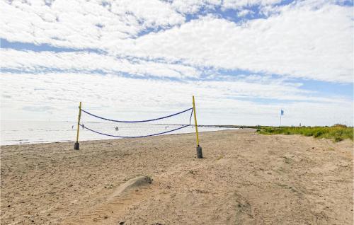 a volleyball net on a sandy beach near the ocean at Awesome Home In Falkenberg With Wifi in Falkenberg