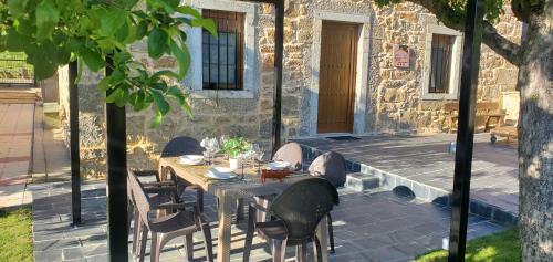 un tavolo e sedie seduti su un patio di Casa Rural Carmen Luna a Miñera de Luna