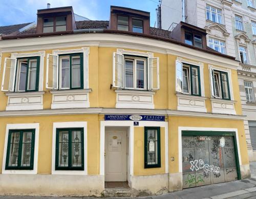 un edificio giallo con graffiti sul lato di Appartement Pension 700m zum Ring a Vienna
