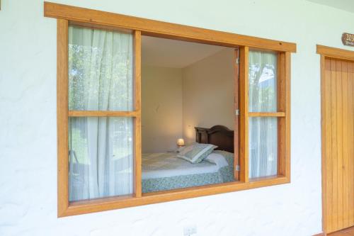 ein Schlafzimmer mit einem Fenster mit einem Bett in der Unterkunft Hostería Paraíso in Vilcabamba