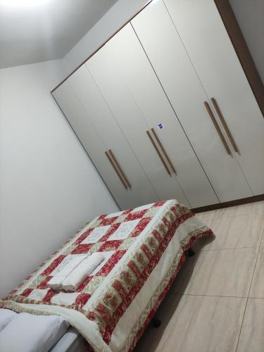 a bedroom with a bed and two white cabinets at APTO EM CONDOMÍNIO FECHADO ( B1-304) in Rio Verde