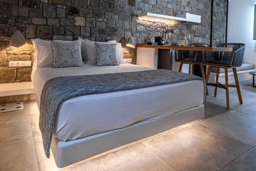 a bedroom with a large bed and a desk at Manesis Suites in Pollonia