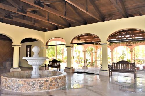 a lobby with a fountain in the middle of a building at HACIENDA MONARCAS Resort in Puerto Peñasco