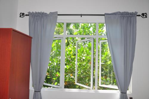 a window with white curtains in a room at Jungle Fence in Bentota