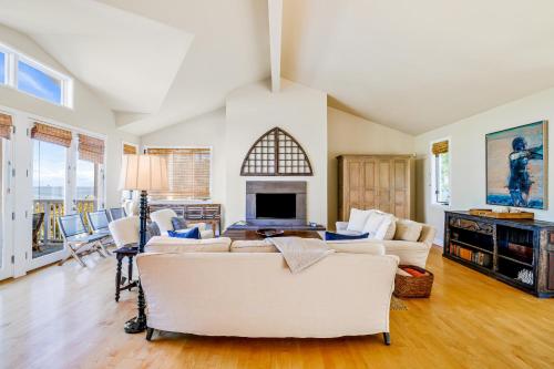 a living room with white furniture and a fireplace at Golden Getaway in Summerland