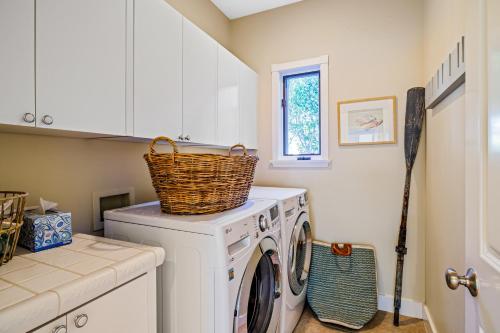 a laundry room with a washing machine with a basket on top at Golden Getaway in Summerland