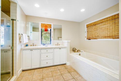 a white bathroom with a tub and a sink at Golden Getaway in Summerland