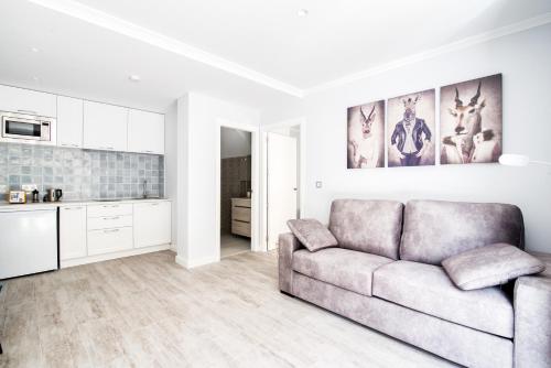 a living room with a couch and a kitchen at Mar Apartments Alicante, Playa de San Juan in Alicante
