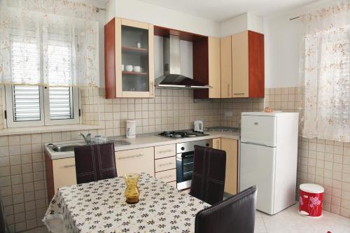 a kitchen with a table and a white refrigerator at Apartments by the sea Korcula - 6016 in Korčula