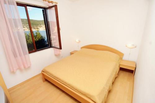 a small bedroom with a bed and a window at Apartments by the sea Vinisce, Trogir - 5982 in Vinišće