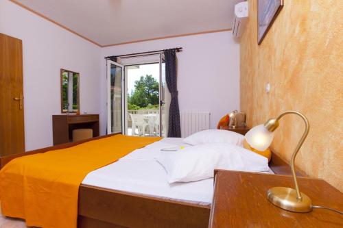 a bedroom with a bed and a desk with a lamp at Apartments and rooms by the sea Brela, Makarska - 6056 in Brela