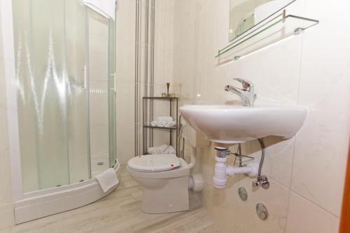 a bathroom with a sink and a toilet and a shower at Apartments and rooms by the sea Brela, Makarska - 6056 in Brela