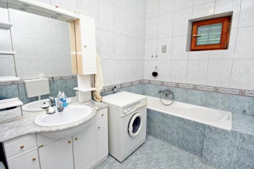 La salle de bains est pourvue d'un lave-linge, d'un lavabo et d'un lave-linge. dans l'établissement Apartments with a parking space Vinisce, Trogir - 5978, à Vinišće