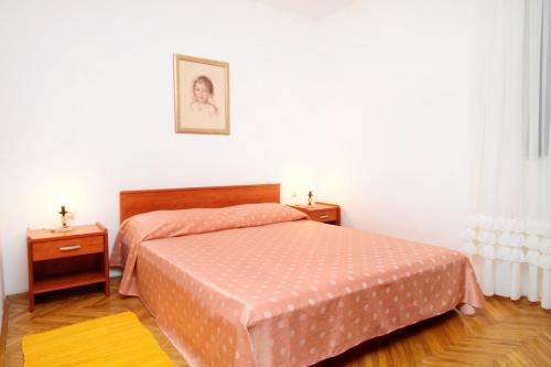 ein kleines Schlafzimmer mit einem Bett und zwei Nachttischen in der Unterkunft Apartments by the sea Vinisce, Trogir - 5981 in Vinišće