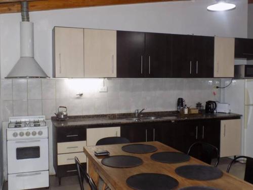 a kitchen with a table and a stove top oven at Encantador departamento in San Rafael