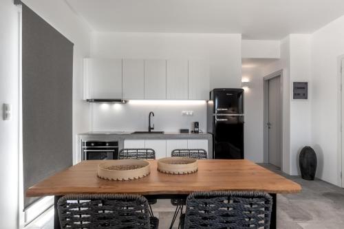 a kitchen with a wooden table and some chairs at Manesis Suites in Pollonia