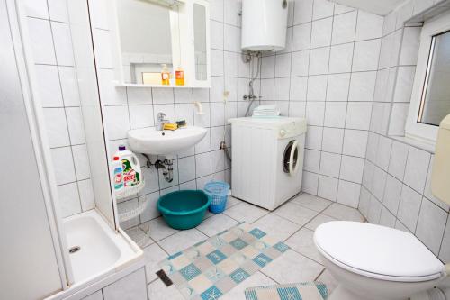 Baño blanco con aseo y lavamanos en Apartments with a parking space Supetar, Brac - 6036, en Supetar