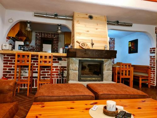 a living room with a fireplace and a table at СПА къща за гости Каза Роза - Swiss Style Chalet Casa Rosa SPA Guest House in Kyustendil