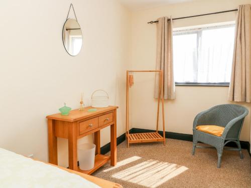 a bedroom with a desk and a mirror and a chair at No 5 Main Street in Hull
