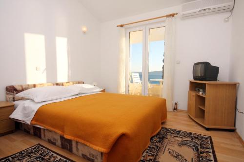 a bedroom with a bed and a tv and a window at Apartment Pisak 5975d in Pisak