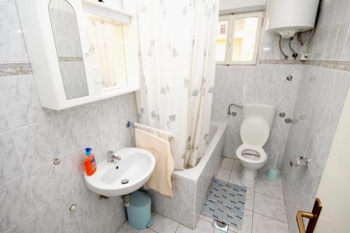 bagno bianco con lavandino e servizi igienici di Apartments by the sea Kastel Stari, Kastela - 6059 a Kaštela (Castelli)