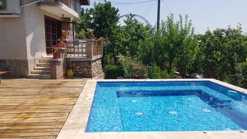 uma piscina no quintal de uma casa em Къща за гости Каза Роза - Swiss Style Chalet Casa Rosa Guest House em Kyustendil