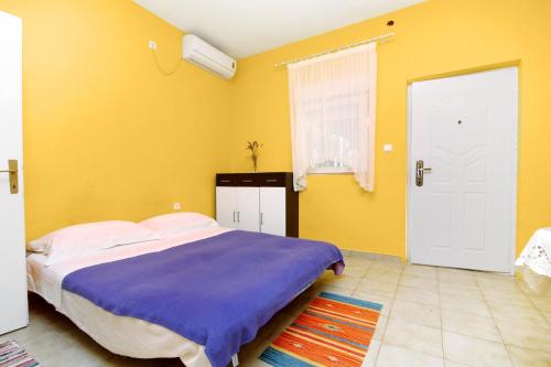 ein Schlafzimmer mit einem Bett und einer gelben Wand in der Unterkunft Seaside holiday house Bibinje, Zadar - 5854 in Bibinje