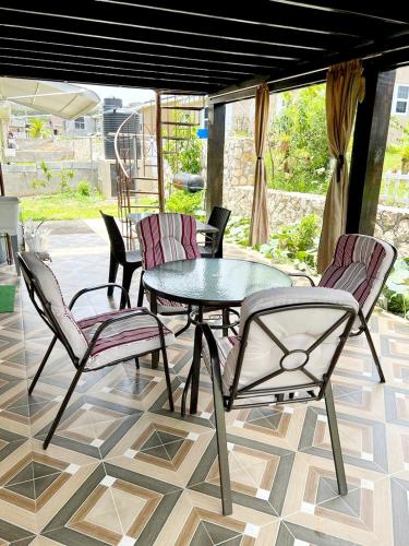a patio with a table and chairs on a tile floor at L&V Paradise Vacation Home with Pool and Gym in Falmouth
