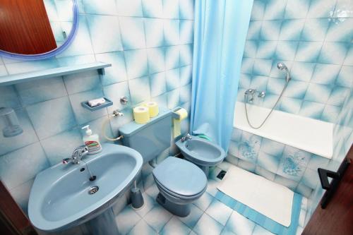 La salle de bains bleue est pourvue de toilettes et d'un lavabo. dans l'établissement Apartments by the sea Lokva Rogoznica, Omis - 6004, à Lokva Rogoznica