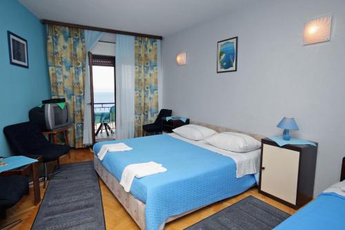 a bedroom with a blue bed and a television at Apartments by the sea Lokva Rogoznica, Omis - 6004 in Lokva Rogoznica