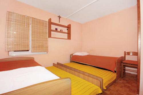 a small room with two beds and a window at Apartments with a parking space Omis - 5988 in Omiš