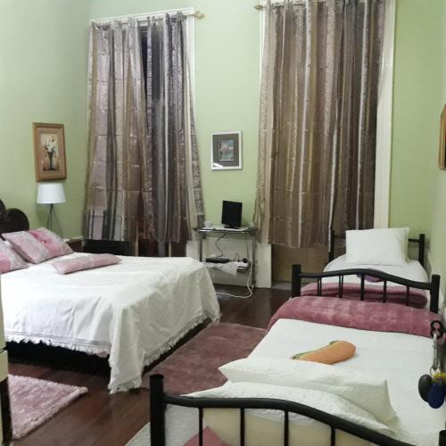 a bedroom with two beds and a table with a laptop at Casa dragão in Porto