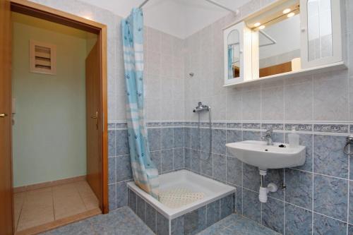 een badkamer met een wastafel, een douche en een wastafel bij Apartments with a parking space Slatine, Ciovo - 5999 in Slatine