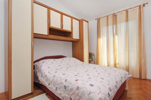 een slaapkamer met een bed met een boekenplank erboven bij Apartments with a parking space Slatine, Ciovo - 5999 in Slatine