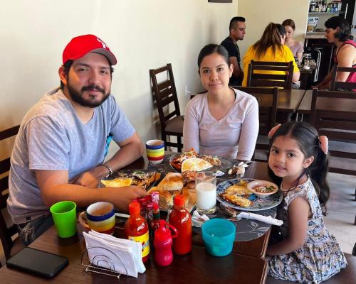 a man and a woman sitting at a table with food at Hotel Gesa in Villa Corona