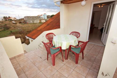 eine Terrasse mit einem Tisch und Stühlen auf dem Balkon in der Unterkunft Apartments by the sea Ljubac, Zadar - 5947 in Ljubač