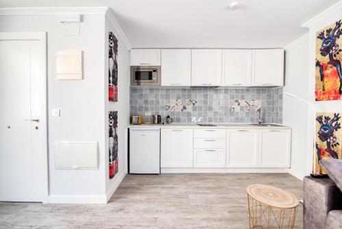 a kitchen with white cabinets and a couch at Mar Apartments Alicante, Playa de San Juan in Alicante