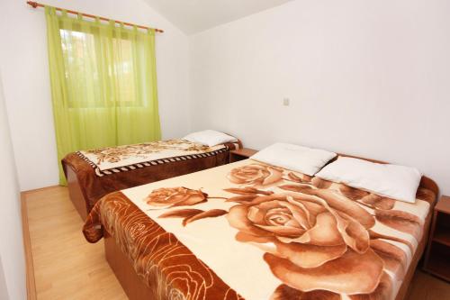 Un dormitorio con dos camas y una manta rosa. en Seaside apartments with a swimming pool Nin, Zadar - 5930, en Nin