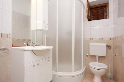 Un baño con inodoro, lavabo y ducha. en Seaside apartments with a swimming pool Nin, Zadar - 5930, en Nin