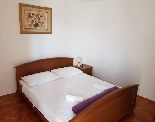 een slaapkamer met een groot bed met witte lakens bij Apartments by the sea Nin, Zadar - 5937 in Nin