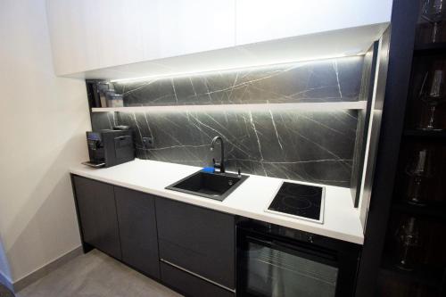 a kitchen with a sink and a stove at Jacuzzi Sauna SelfCheckIn Mystic in Mostar