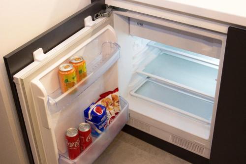 an open refrigerator with drinks and snacks in it at Jacuzzi Sauna SelfCheckIn Mystic in Mostar