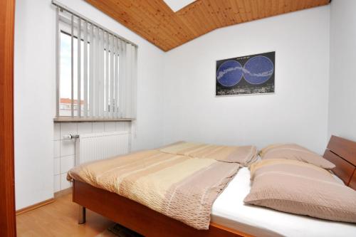 uma cama num quarto branco com uma janela em Apartments with a parking space Nin, Zadar - 5929 em Nin