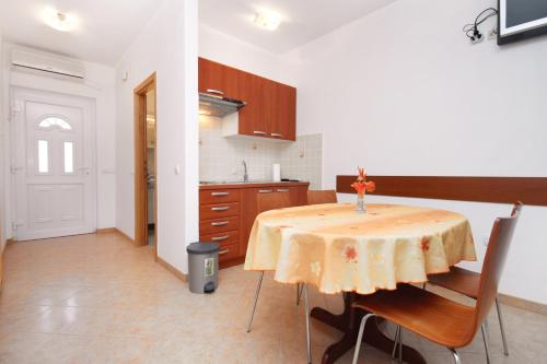 uma cozinha com uma mesa com uma toalha de mesa amarela em Apartment Tkon 6215c em Tkon