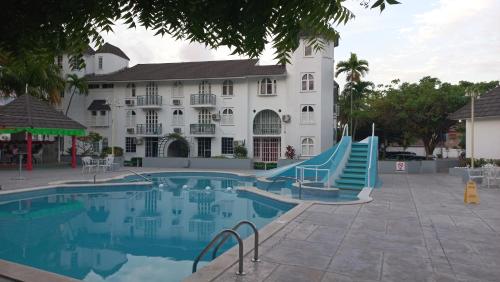 a hotel with a swimming pool and a building at Beautiful Balcony by the Sea Studio in Ocho Rios
