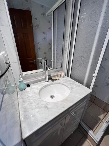 a bathroom with a sink and a mirror at Hotel Boutique Family Suites in Panguipulli